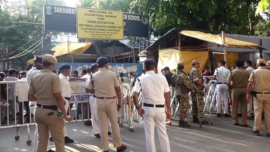 Security personnel and officials outside a vote counting centre during the West Bengal Assembly election results day, in Kolkata. (PTI)