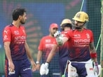 Bhuvneshwar Kumar (left) and Virat Kohli (right) chat during a training session in Lucknow on Tuesday. (SOURCED)