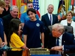 President Donald Trump speaks with children before signing a proclamation in the Oval Office at the White House, in Washington. 