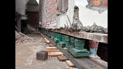 The building has been lifted using a network of jacks. Green hydraulic jacks hold the structure from below, while grey jacks —fitted with rollers — are used to move it forward. (HT Photo) The building has been lifted using a network of jacks. Green hydraulic jacks hold the structure from below, while grey jacks —fitted with rollers — are used to move it forward. (HT Photo)