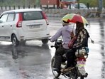 People are seen enjoying light rain along NH-9 near Dasna in Ghaziabad, on April 29. (HT File Photo)