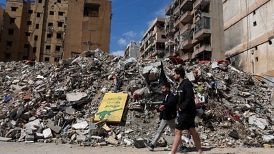People walk at the site of an earlier Israeli strike on the southern suburbs of Beirut, Lebanon. (REUTERS)