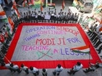 School students hold national flags around a rangoli bearing a message on 'Operation Sindoor' in Jammu. (PTI)
