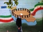 An Iranian man walks past the map of Iran, with its citizens holding hands, painted on a wall in the capital Tehran. Iran has questioned the seriousness of American diplomacy, in the wake of renewed naval clashes in the Gulf.