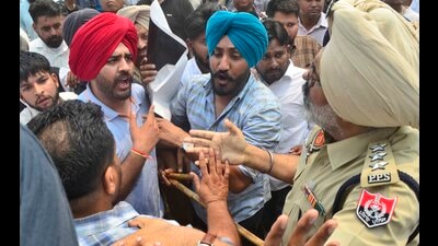 Protesters arguing with a police official during a protest near Gill Road on Sunday. (Gurpreet Singh/HT)