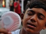 Thane, India - May -11 2026:The temperature has risen again in the state, A boy is seen using a mini fan to cool his face and protect himself from the heat.,in Thane ,in Mumbai, India, on, Monday, May -11, 2026. ( photo by Praful Gangurde / Hindustan Times )