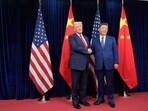 President Donald Trump, left, and Chinese President Xi Jinping, right, shake hands before their meeting before their meeting at Gimhae International Airport in Busan.