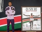 Kenyan marathon runner Sabastian Sawe poses on stage. 