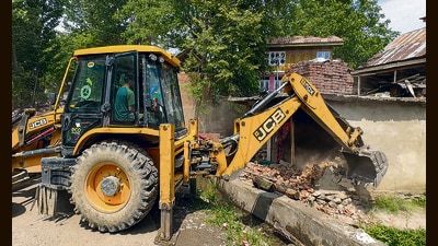 A demolition drive being carried out by Anantnag revenue department in coordination with Kulgam police against a drug peddler as part of the continued crackdown at Drinen Qazigund, in Anantnag on Tuesday. (PTI)