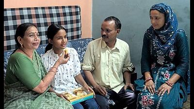 Rewari’s Deepika, celebrates with family members after securing the top position in Haryana in the Class 12 Board examinations. (Manoj Dhaka/HT)