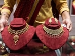 A saleswoman shows gold necklaces on display inside a jewellery showroom in Kolkata.