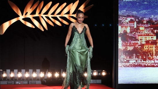 Ruth Negga turned heads in a plunging neckline green gown featuring intricate black lace detailing by Dior, paired with elegant jewellery from Chopard.(AFP)