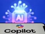 A photo taken on May 7, 2026 shows the letters AI for Artificial Intelligence on a laptop screen (top) next to the logo of the Microsoft's Copilot chatbot application on a smartphone screen in Frankfurt am Main, western Germany. (Photo by Kirill KUDRYAVTSEV / AFP)