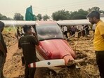 Security officials conduct a rescue operation after a trainer aircraft operated by a private company crash-lands following a technical snag, at Baramati. (PTI)