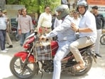 Following Prime Minister Narendra Modi's appeal to reduce fuel usage, Ghaziabad district magistrate Ravindra Kumar Mandar bike-pools to work on Friday morning. (Sakib Ali/HT Photo)