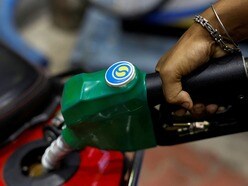 FILE PHOTO: A worker holds a nozzle to pump fuel into a two-wheeler vehicle at a Bharat Petroleum oil and fuel station in Kolkata, India, August 7, 2024. REUTERS/Sahiba Chawdhary/File Photo