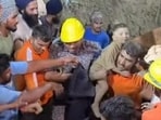 Rescuers with the child after being pulled out of the 30-ft borewell in Chak Samana village on the Hoshiarpur-Dasuya road on Friday night. (HT)