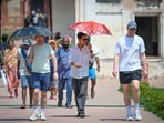 Tourists seen shielding themselves from the scorching heat at Humayun's Tomb on Sunday. (Sanchit Khanna/HT Photo)