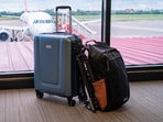 A neatly packed backpack and spinner suitcase side by side at an airport, ready for holiday, business trips and everything. (Canva.com)