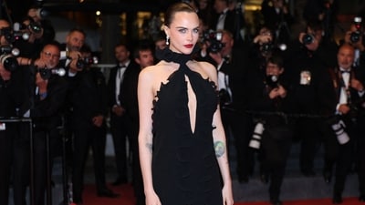 British actor Cara Delevingne poses on the Cannes red carpet in a cut-out black frilled dress during the screening of the film Club Kid. The ensemble showed off her tattoos. Diamond earrings, bold red lips, and a sleep top knot rounded off the styling.&nbsp; (AFP)