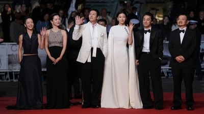Jun Ji-hyun poses with Kim Shin-rok, Shin Hyun-been, Ji Chang-wook, Koo Kyo-hwan and director Yeon Sang-ho. She wore a white floor-length look with cape sleeves, ornate gold brooches, and a tailored silhouette.&nbsp; (AP Photo/Andreea Alexandru)