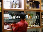 A salesman arranges liquor bottles inside a liquor store in Bengaluru, India. (REUTERS)