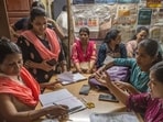 In Ramabai Ambedkar Nagar, teachers appointed for Census duty go through documents along with Asha workers on Saturday. (Satish Bate/Hindustan Times)