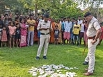 Police personnel conduct investigation after a large number of Electoral Photo Identity Cards (EPIC) were found scattered in a field, in Birbhum district, West Bengal, Sunday. (PTI)