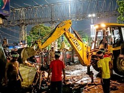 Howrah: Civic workers carry out an anti-encroachment drive to remove illegal shops near the Howrah Railway Station area, West Bengal, Saturday night, May 17, 2026. (PTI Photo) (PTI05_17_2026_000042B)