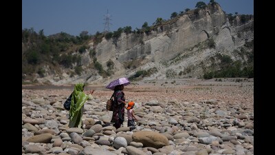 A woman carries an umbrella to protect herself from the heat on a hot summer day on the outskirts of Jammu on Sunday. (AP Photo) A woman carries an umbrella to protect herself from the heat on a hot summer day on the outskirts of Jammu on Sunday. (AP Photo)