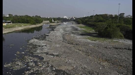 Large stretches of the dried Gomti riverbed reveal plastic waste, sludge and debris in Lucknow on Monday. (Deepak Gupta/HT)