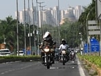 Motorists shield themselves from the noon sun. (Arvind Yadav/HT Photo)