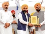 Punjab chief minister Bhagwant Mann and cabinet ministers Harpal Singh Cheema (left) and Tarunpreet Singh Sond (right) during the inauguration of underground electricity wires project at Satoj village in Sangrur on Tuesday. (@BhagwantMann X)