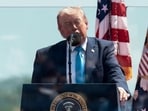President Donald Trump stands behind protective glass as he delivers the commencement address at the US Coast Guard Academy in New London, Connecticut.