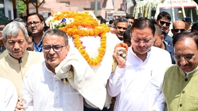 Chief Minister Pushkar Singh Dhami pays floral tributes to former Uttarakhand Chief Minister Major General (Retd.) B.C. Khanduri during the funeral procession in Dehradun. Chief Minister Pushkar Singh Dhami pays floral tributes to former Uttarakhand Chief Minister Major General (Retd.) B.C. Khanduri during the funeral procession in Dehradun.