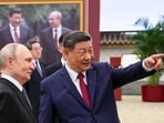 Russian President Vladimir Putin, left, and Chinese President Xi Jinping visit an exhibition by the TASS and Xinhua news agencies at the Great Hall of the People, in Beijing, China, on Wednesday