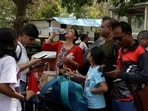 A woman drinks water as her family members try to book a cab outside a railway station during a strike by taxi and autorickshaw unions demanding a hike in fares following surge in fuel prices, in New Delhi, India, May 21, 2026. 