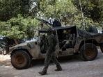 Israeli soldiers in a military vehicle take position