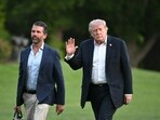 Donald Trump and Donald Trump Jr. walk on the south lawn toward the White House in Washington, DC