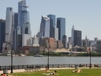 People lay out in the sun in front of the New York City skyline on May 20.
