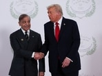 US President Donald Trump and Pakistani Prime Minister Shehbaz Sharif shake hands as they pose for a photo.