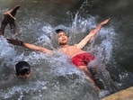 Children cool off in a small pond near the Yamuna river in New Delhi on Wednesday.