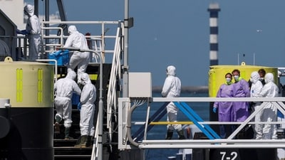People in personal protective suits enter the cruise ship MV Hondius, which was affected by a hantavirus outbreak, after arriving at the Port of Rotterdam (REUTERS)
