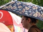 A woman covers herself with an umbrella to protect herself from heatwave, in New Delhi. A woman covers herself with an umbrella to protect herself from heatwave, in New Delhi.