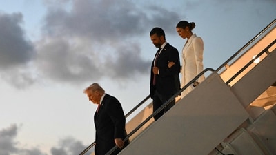 US President Donald Trump, followed by Donald Trump Jr. and Bettina Anderson step off Air Force One upon arrival at Palm Beach International Airport in West Palm Beach, Florida. (AFP) US President Donald Trump, followed by Donald Trump Jr. and Bettina Anderson step off Air Force One upon arrival at Palm Beach International Airport in West Palm Beach, Florida. (AFP)