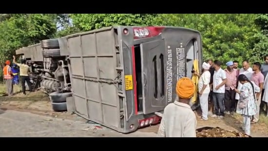 Two students from Jammu were killed after a tourist bus overturned on the Amritsar-Pathankot national highway near Kaler Khurd village in Gurdaspur district on Friday morning. (HT photo)