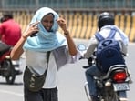 Commuter wrap themselves with cloth to shield themselves from scorching heat.