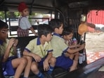 An elderly man offers cold water to children seated inside an auto-rickshaw on a hot summer day in Amritsar. (Sameer Sehgal/HT)