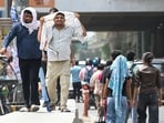 Noida, India-May 23, 2026:To protect themselves from the scorching heat, commuters cover themselves with clothing and use umbrellas.. The India Meteorological Department has issued an orange alert across the National Capital Region warning of severe heatwave conditions.The maximum daytime temperature ranged between 44 degree celsius and 45 degree celsius, in Noida, India, on Saturday, May 23, 2026. (Photo by Sunil Ghosh / Hindustan Times)