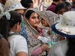 A woman covers herself and a kid on a hot summer day, in New Delhi, Tuesday, May 19, 2026. Delhi experienced a warm Tuesday morning as the minimum temperature settled at 28.2 degrees Celsius while the weather office issued a 'yellow' alert for heatwave conditions, with isolated places in the city likely to reel under intense heat during the day.